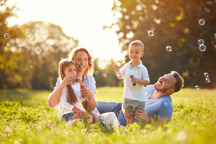 family outside blowing bubbles